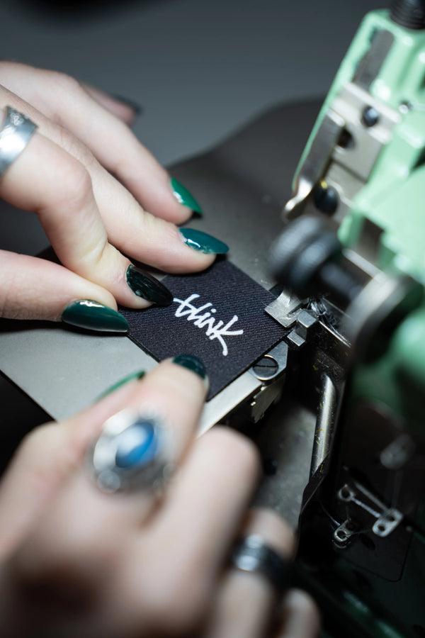 Hands sewing Blink label