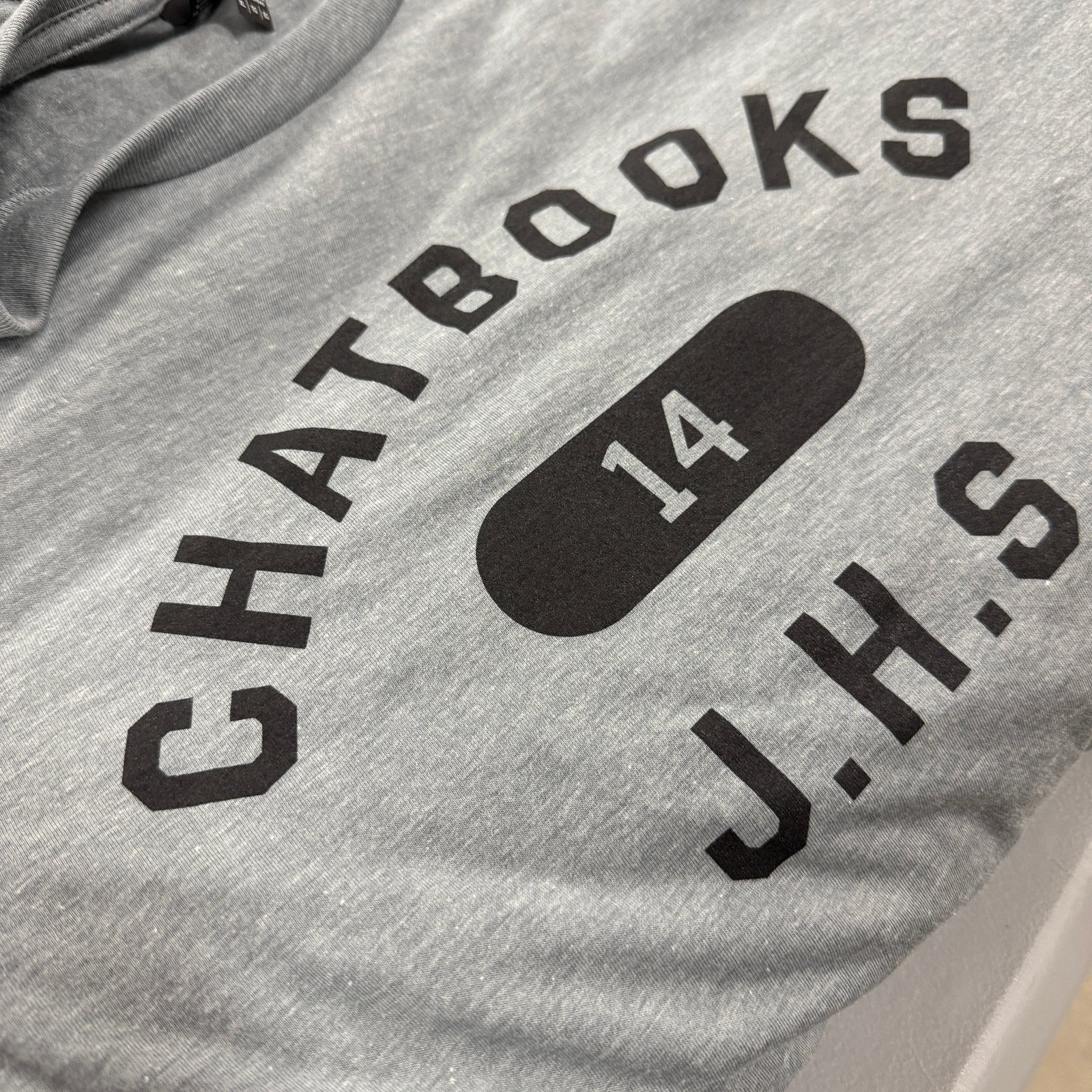 Gray t-shirt with black text and logo on a white background